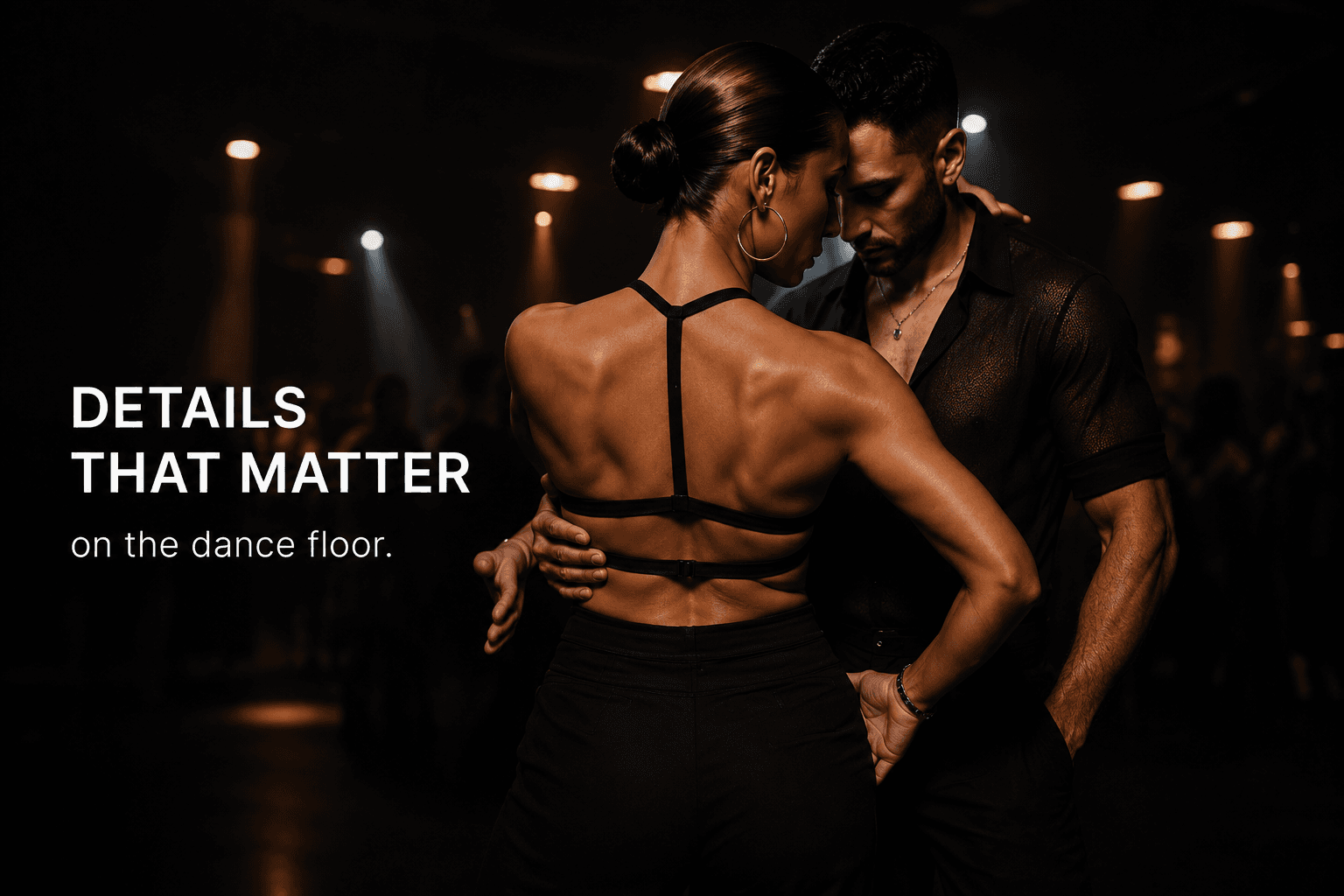Muscular woman and man dancing closely in a dark, atmospheric room with dramatic lighting.